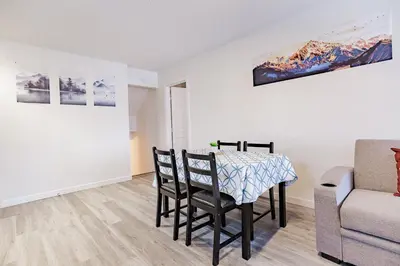a dining room with a table and chairs and a couch at Walkout Basement Suite, 2 BDR 4BD, Bright and Spacious in Calgary