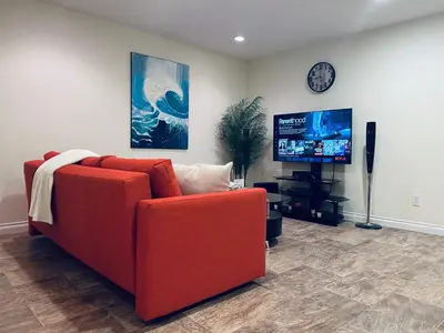 a living room with a red couch and a tv at A private suite in Port Moody in Port Moody
