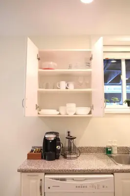 a kitchen with white cabinets and a counter top at A private suite in Port Moody in Port Moody