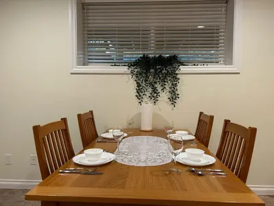 a wooden table with chairs and a vase on it at A private suite in Port Moody in Port Moody