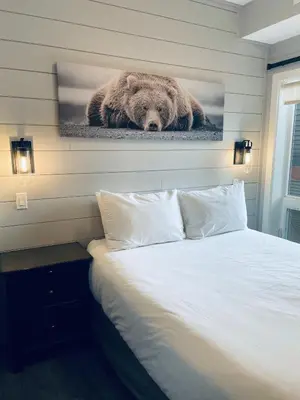 a bed with a picture of a bear on the wall at Family friendly 2BR/2BA condo - Views & Location!! in Canmore