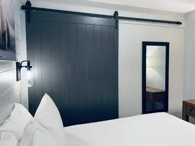 a bedroom with a dark green sliding barn door at Family friendly 2BR/2BA condo - Views & Location!! in Canmore