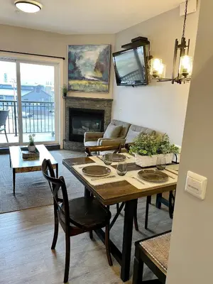 a living room with a table and a tv at Family friendly 2BR/2BA condo - Views & Location!! in Canmore