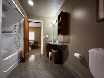 a bathroom with a shower and a sink and a toilet at Solara Escape - 2BR Retreat with Pool - Hot Tub - Gym - Spa in Canmore