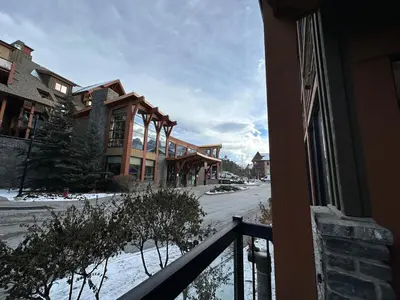 a view from a balcony of a building in the snow at Solara Escape - 2BR Retreat with Pool - Hot Tub - Gym - Spa in Canmore