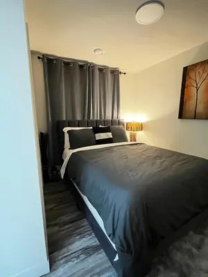 a bedroom with a large bed with gray sheets at Cozy Haven! in Edmonton