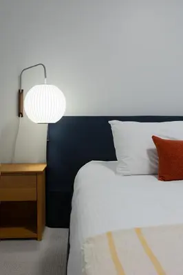 a bedroom with a bed with a lamp and a table at Tally Ho by Revelstoke Vacations in Revelstoke