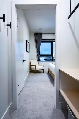 a white room with a bed and a window at Tumbledown Condo by Revelstoke Vacations in Revelstoke