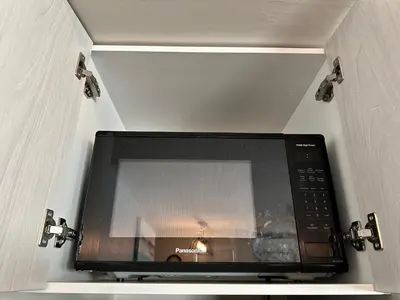 a microwave oven in a cabinet with its door open at B211 MTN View ground floor town house- 2BD, Sleeps 8, hot tub, free parking, close to Banff in Canmore