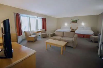 a hotel room with a bed and a living room at Eldorado, a Coast Hotel in Dawson City