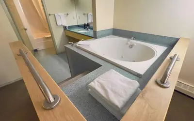 a large bathroom with a tub and a sink at Eldorado, a Coast Hotel in Dawson City