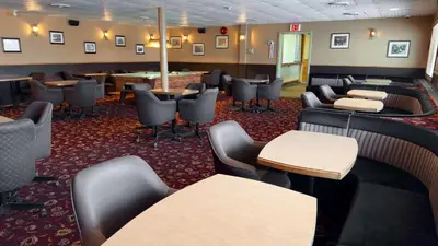 a waiting room with couches and tables and chairs at Eldorado, a Coast Hotel in Dawson City