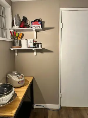 a kitchen with a table with a door and a shelf at West Edmonton Perle Palace in Edmonton