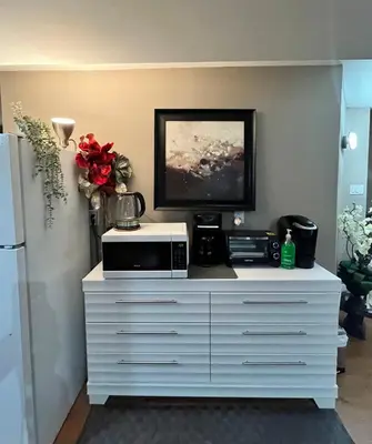 a white dresser with a tv on top of it at West Edmonton Perle Palace in Edmonton