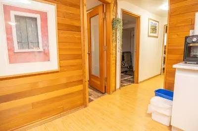 a hallway with wood paneled walls and a door at 3 Bedroom Gardenside Downtown Home in Whitehorse