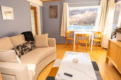 a living room with a couch and a table at 3 Bedroom Gardenside Downtown Home in Whitehorse