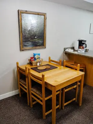 a wooden table with four chairs and a kitchen at Cozy apartment in the heart of Panorama in Panorama
