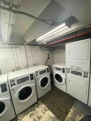 a laundry room with three washing machines and a light at Cozy apartment in the heart of Panorama in Panorama