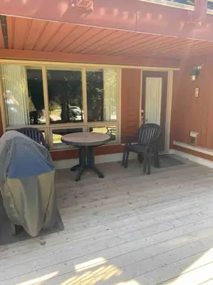 a screened in porch with a table and two chairs at Cozy apartment in the heart of Panorama in Panorama