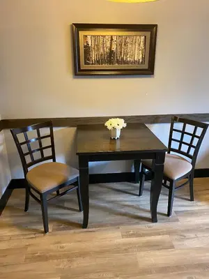 a table with two chairs and a vase with flowers on it at Sweet Condo Canmore GR\uff1a\uff09 in Canmore