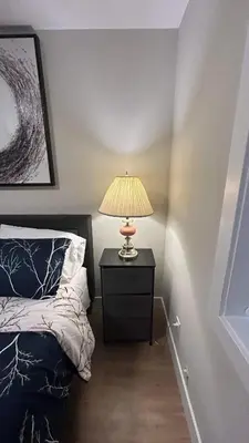 a bedroom with a bed and a lamp on a night stand at New, Spacious 2 Bedrooms in Downtown With Free Parking! in Maple Ridge District Municipality