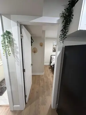 a hallway with an open door with plants at New, Spacious 2 Bedrooms in Downtown With Free Parking! in Maple Ridge District Municipality