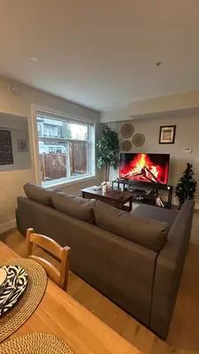 a living room with a couch and a fireplace at New, Spacious 2 Bedrooms in Downtown With Free Parking! in Maple Ridge District Municipality