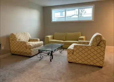 a living room with two chairs and a coffee table at New Townhouse in Red Deer in Red Deer