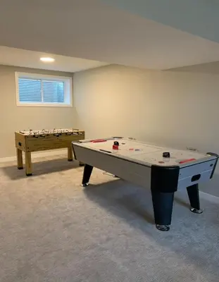 a ping pong table in an empty room with a table at New Townhouse in Red Deer in Red Deer