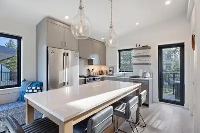 a kitchen with a table and chairs in a room at Ocean View Townhouse #26 at THE BEACH HOUSE in Campbell River