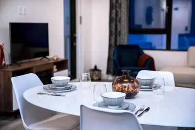a white table with plates and glasses and a vase at Revelstoke Marvel - Two Bedroom with Hot Tub in Revelstoke