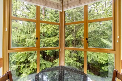a room with a large window looking out at a forest at Cascade by Elevate Vacations in Whistler
