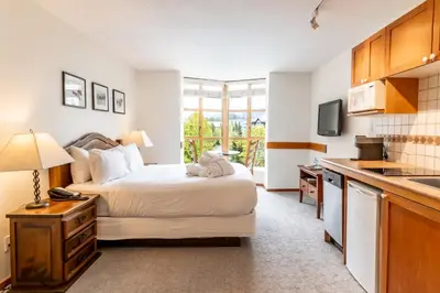 a hotel room with a bed and a kitchen at Cascade by Elevate Vacations in Whistler