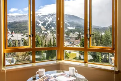 a room with four windows with a table and a mountain view at Cascade by Elevate Vacations in Whistler