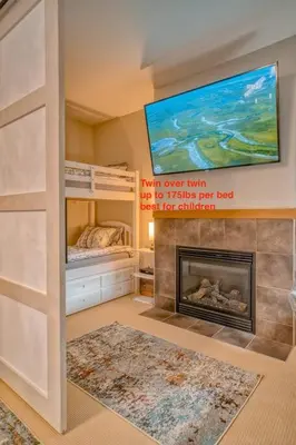 a bedroom with a bunk bed and a fireplace at Mountain Escape sleeps 10 Guests in this 3BD 2BT Top Floor Condo with Mountain View in Canmore