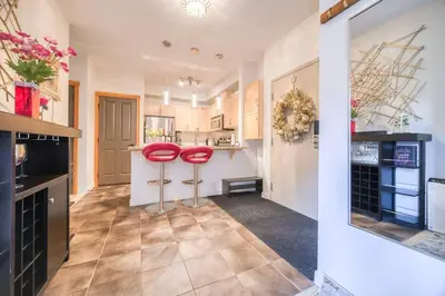 a kitchen with two red stools in a room at Mountain Escape sleeps 10 Guests in this 3BD 2BT Top Floor Condo with Mountain View in Canmore