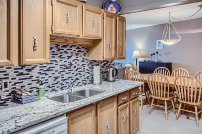 a kitchen with a sink and a table with chairs at Ponderosa Inn by Okanagan Premier in Big White