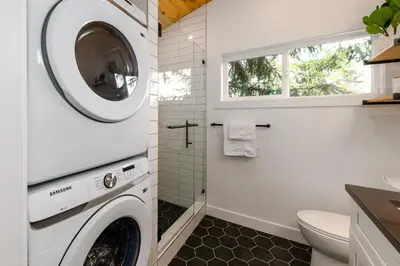 a laundry room with a washer and dryer at Coastal Creative Garden Studio in Colwood