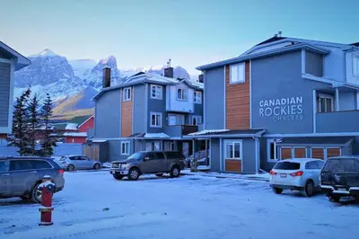 a parking lot with cars parked in front of buildings at Mountain View 3br Loft Walk To Dt king fireplace in Canmore