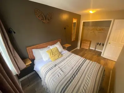 a bedroom with a bed with two yellow pillows at Mountain View 3br Loft Walk To Dt king fireplace in Canmore