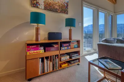 a living room with a book shelf filled with books at CLIFF CABIN Family Friendly|Hot Tub|Spectacular Views in Fairmont Hot Springs