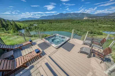 a deck with a hot tub and two chairs on it at CLIFF CABIN Family Friendly|Hot Tub|Spectacular Views in Fairmont Hot Springs