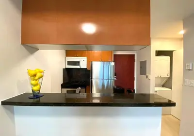 a kitchen with a counter with a vase of bananas on it at Richard Comfort Living in Vancouver