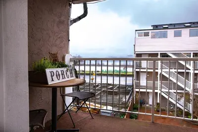 a balcony with a table and a view of a building at The Nook, Top Floor Suite with Lake and Mtn View in Harrison Hot Springs