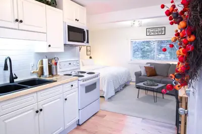 a kitchen and living room with a bed at The Nook, Top Floor Suite with Lake and Mtn View in Harrison Hot Springs