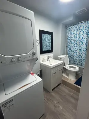 a bathroom with a white sink and a toilet at Cute Highlandpark (Lower B Unit) in Calgary