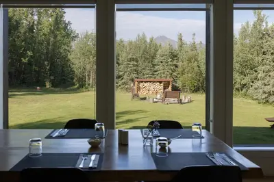a dining room with a table and a large window at Boreale Ranch in Carcross