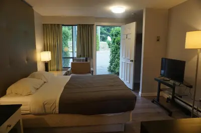 a hotel room with a bed and a television at The Mighty Fraser Motel in Boston Bar