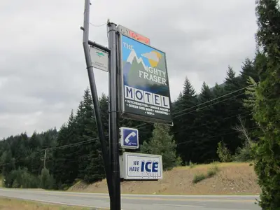 a sign for a motel on the side of a road at The Mighty Fraser Motel in Boston Bar