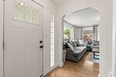 a white door leading to a living room with a couch at Stunning Heritage Home, Sleep 8, Hot Tub, Private Yard, Firepit in Vernon
